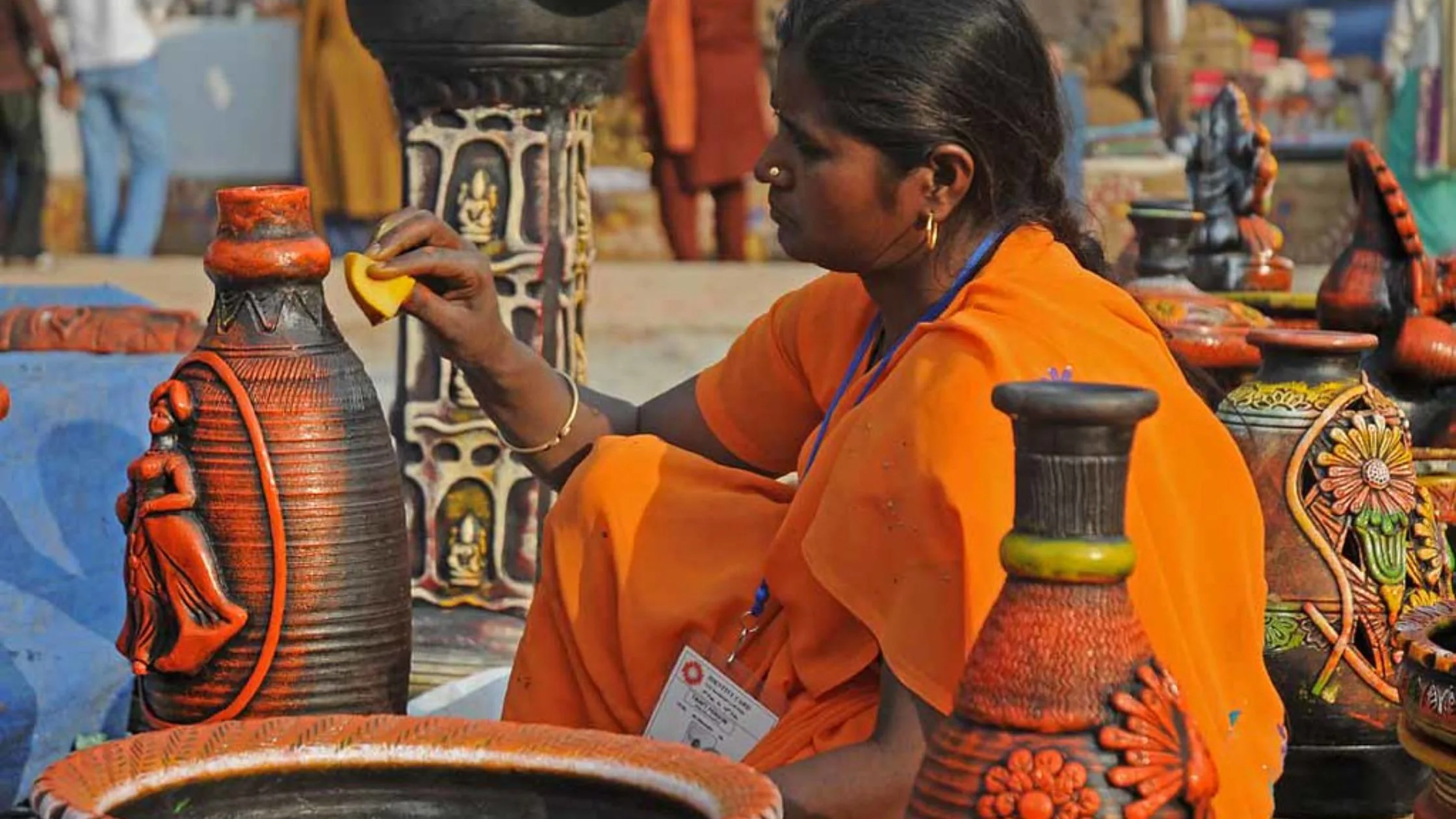 Tribal lady painting a pot. 