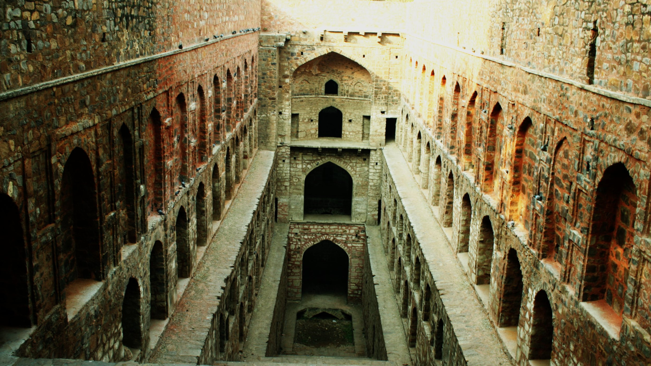 A structure with windows and stairs leading to waterbody. 