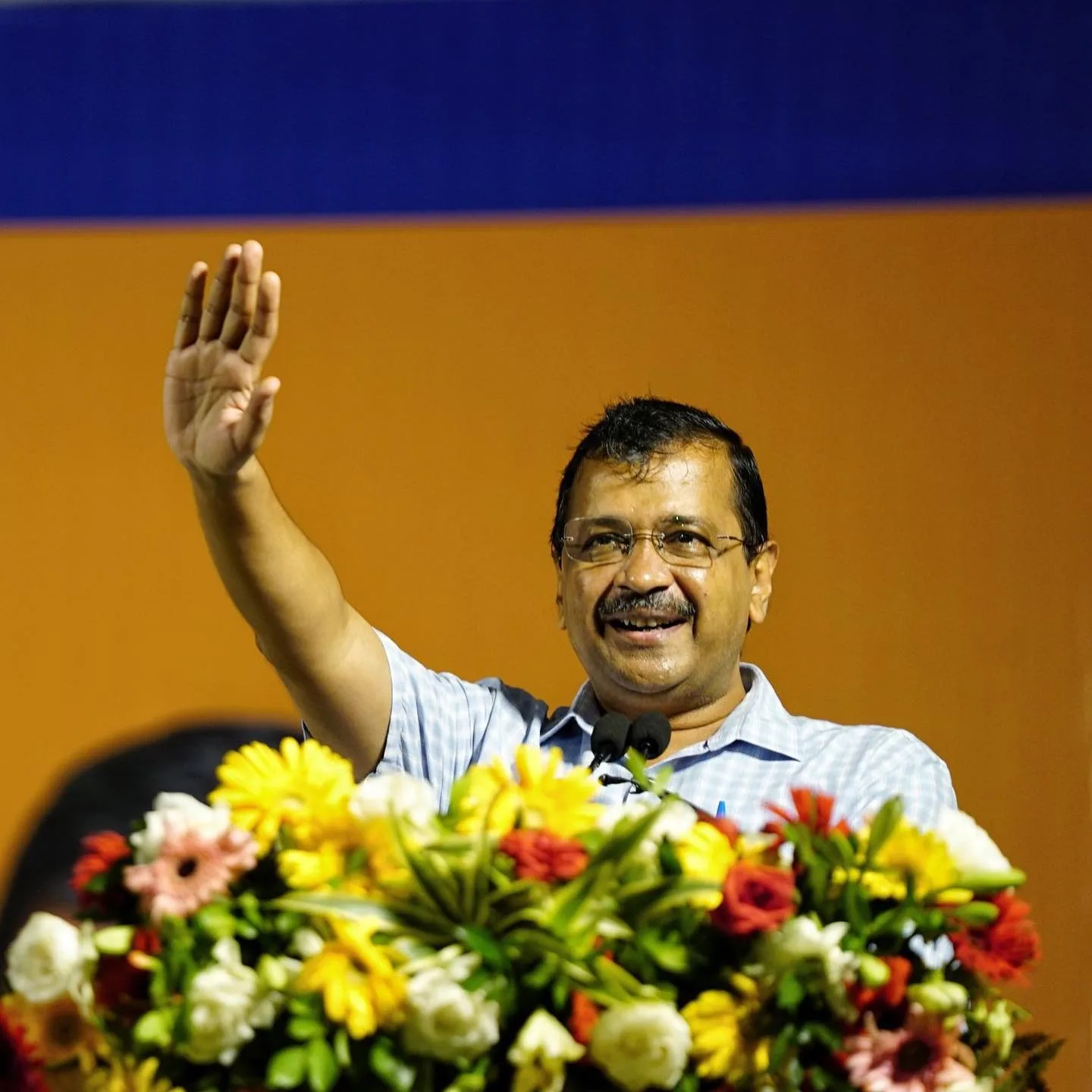 CM Kejriwal waving hands while addressing the people of Delhi. 