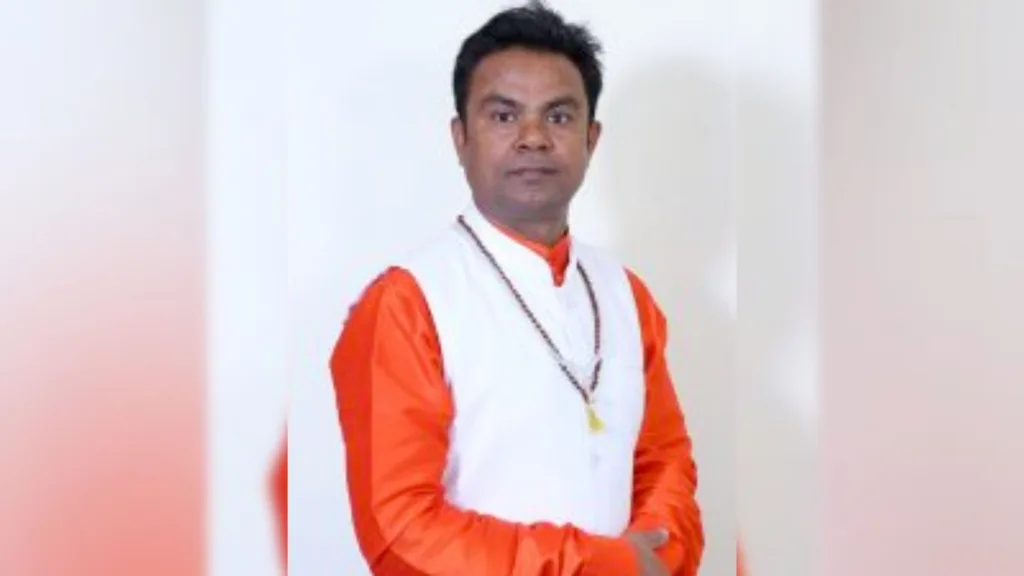 An image of Astrologer Ashok. He is wearing orange colored clothes.